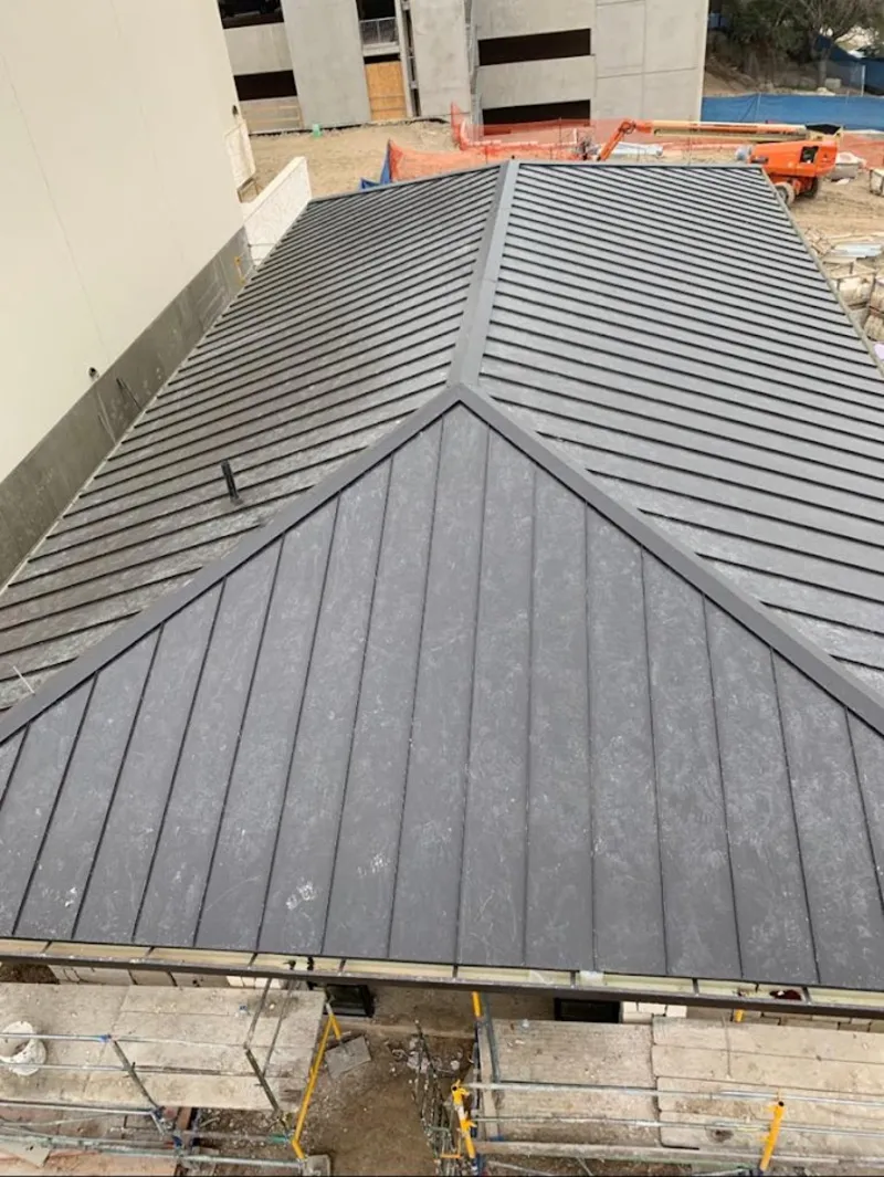 Commercial metal roof construction with crane equipment in Thornapple